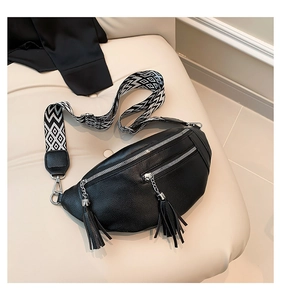 Détail du sac ceinture en cuir grainé noir avec fermetures éclair et pompons longs