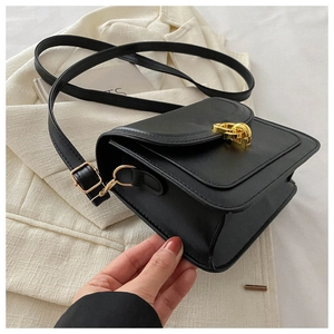 Detailed side view of black matte leather small square bag with golden chain lock