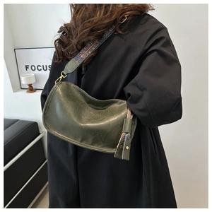 Détail du sac bandoulière demi-lune vert foncé avec bandoulière tissée style ethnique