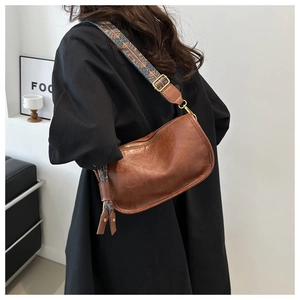 Détail du sac demi-lune marron avec large bandoulière au motif style ethnique