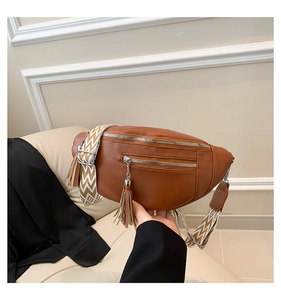 Détail du sac banane en cuir marron avec gland et bandoulière tissée géométrique