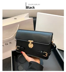 Detailed view of black vintage square bag featuring golden round metal twist lock clasp