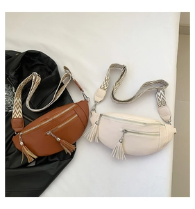 Vue détaillée de deux sacs bandoulière en cuir PU avec pompons et sangles géométriques