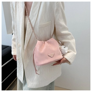 Pink drawstring bucket bag with litchi texture and cute white pompom keychain detail