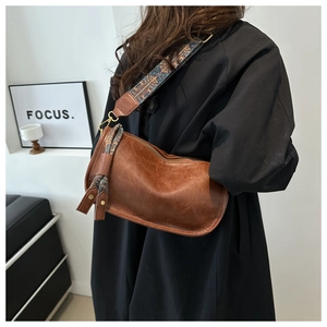 Sac bandoulière en cuir ciré marron avec sangle brodée et décoration à glands