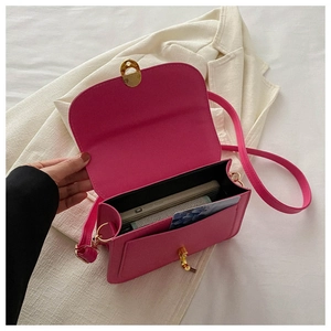Detail view of rose red crossbody bag interior with gold metal buckle and card slot