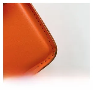 Gros plan sur un sac en cuir orange avec texture grainée et coutures foncées soignées