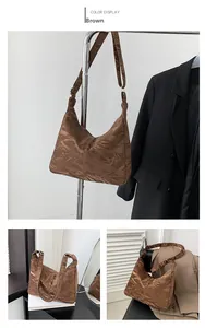 Detail of brown pleated shoulder bag with metallic finish and adjustable strap