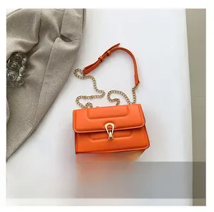 Vue à plat d'un sac bandoulière orange vif avec chaîne dorée et smartphone pour la taille