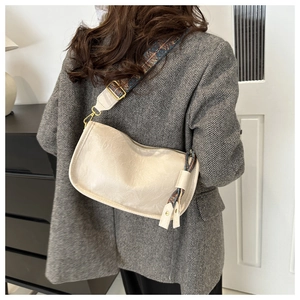 Sac bandoulière demi-lune blanc cassé avec une large sangle brodée au style ethnique