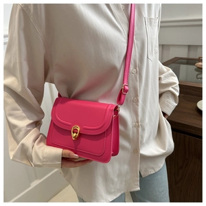 Detail of rose pink crossbody bag with gold hardware ring and adjustable strap
