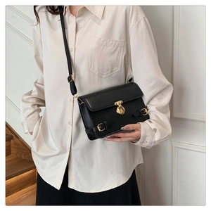 Chic black matte PU crossbody bag with golden round twist lock shown on model indoors