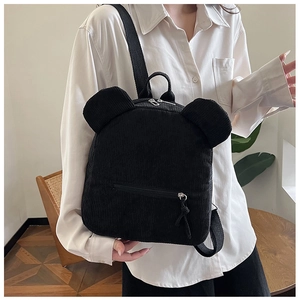 Détail d'un sac à dos en velours côtelé noir avec oreilles d'ours porté par un mannequin