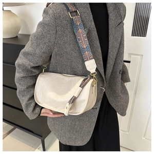 Détail du sac cabas en cuir crème avec bandoulière ethnique et pompon sur mannequin