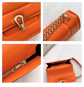 Détails du sac bandoulière en cuir orange avec boucle fer à cheval et chaîne dorée