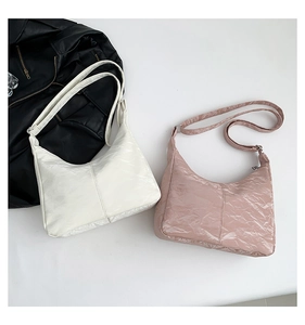 Detail view of stylish crinkled hobo bags in cream and pink with vertical stitching