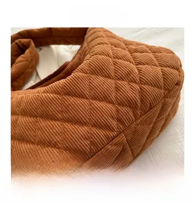 Macro shot of brown corduroy fabric with classic quilted diamond pattern and soft texture
