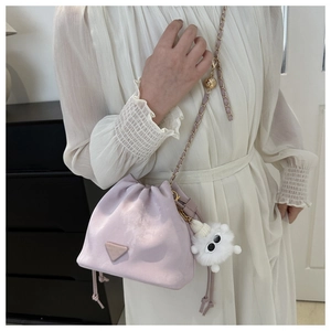 Close-up of lavender drawstring bucket bag with gold chain and white plush charm