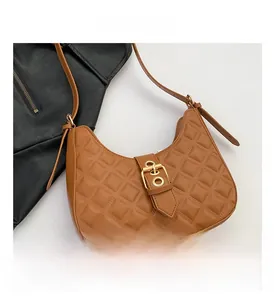Détail du sac croissant matelassé marron avec une grande boucle dorée vintage