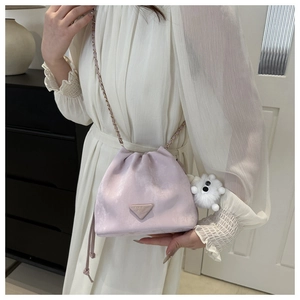 Detail view of light purple velvet drawstring bucket bag with gold chain and plush charm