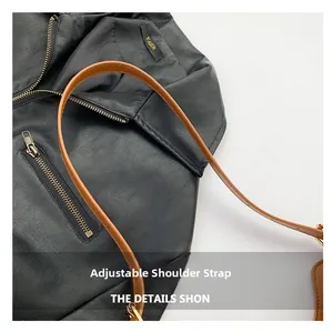 Détail de la bandoulière réglable en cuir marron avec des boucles métalliques