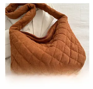 Detailed close-up of quilted brown corduroy fabric and rhombus stitching on the large tote bag