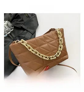 Close-up of brown quilted faux leather handbag with decorative thick gold chain and strap