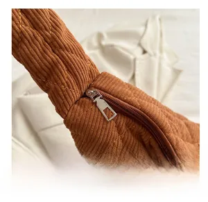 Detail of smooth silver zipper on brown corduroy quilted tote bag with diamond pattern