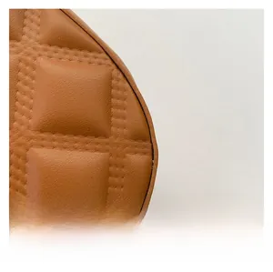 Gros plan sur la texture en cuir matelassé marron avec coutures détaillées du sac