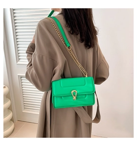 Vue détaillée du sac bandoulière vert vif avec boucle fer à cheval dorée et chaîne en métal