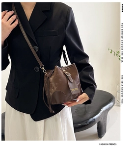 Detail view of a vintage dark brown bucket bag with textured faux leather and hanging tag