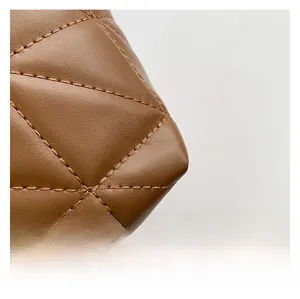 Detail of brown quilted leather bag featuring high-quality stitching and fine texture
