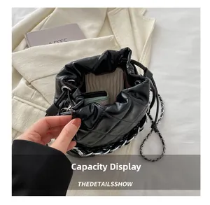 Detail of black quilted bucket bag showing interior storage capacity and silver chain