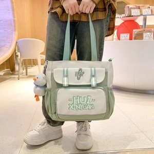 Large casual canvas tote bag with multi-pocket patchwork design and plush duck keychain
