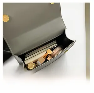 Vue macro montrant la grande capacité du sac en velours avec téléphone et maquillage