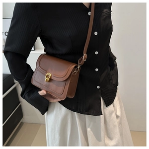 Detailed close-up of the vintage brown PU leather shoulder bag with gold twist lock