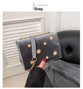 Détail du sac en velours gris avec fleurs de tournesol dorées et bandoulière