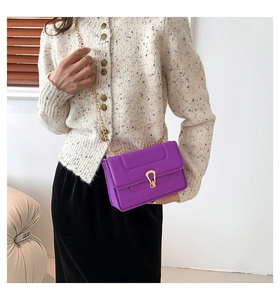 Détail du sac bandoulière violet avec boucle fer à cheval dorée et chaîne en métal
