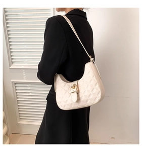 Détail du sac croissant blanc avec surpiqûres en losange et boucle dorée élégante