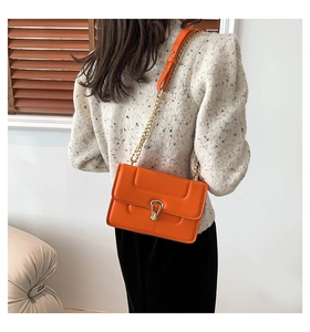 Détail du sac à bandoulière orange avec fermoir doré en forme de goutte d'eau