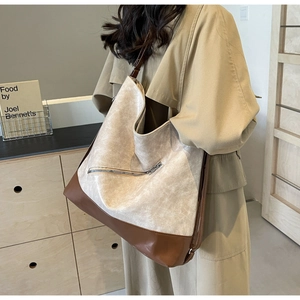 Detail of a large two-tone beige and brown tote bag showing its spacious design and texture