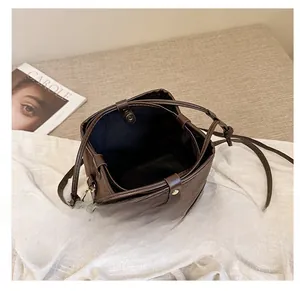 Detailed interior view of the dark brown bucket bag featuring a magnetic snap closure