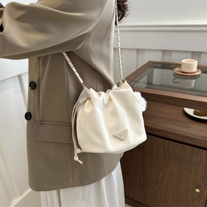 Chic beige bucket bag with gold chain strap and drawstring closure for women