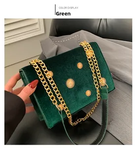 Gros plan d'un sac à chaîne en velours vert avec ornements tournesol dorés et sangle