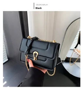 Détail du sac à bandoulière noir matelassé avec fermoir doré en U et sangle de chaîne