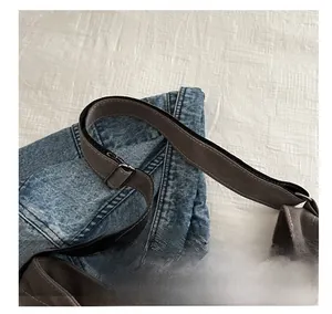 Detailansicht aus blauem Denim und grauem Canvas-Schultergurt mit verstellbarer Metallschnalle