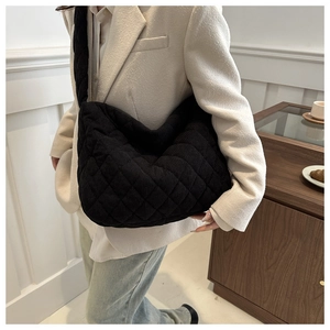 Detail of black quilted corduroy tote bag showing soft texture and diamond stitch patterns