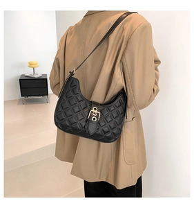 Chic sac hobo en cuir matelassé noir avec détails dorés porté par un mannequin
