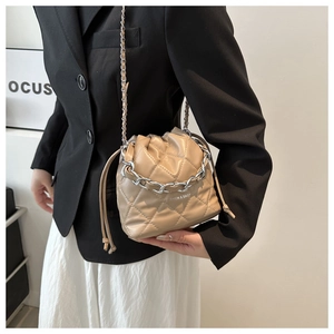 Detail of quilted bucket bag with silver chain handle and textured PU leather finish