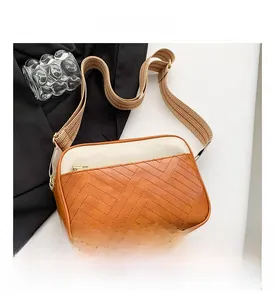 Close-up of the stylish color-block crossbody bag with herringbone stitching and gold zipper